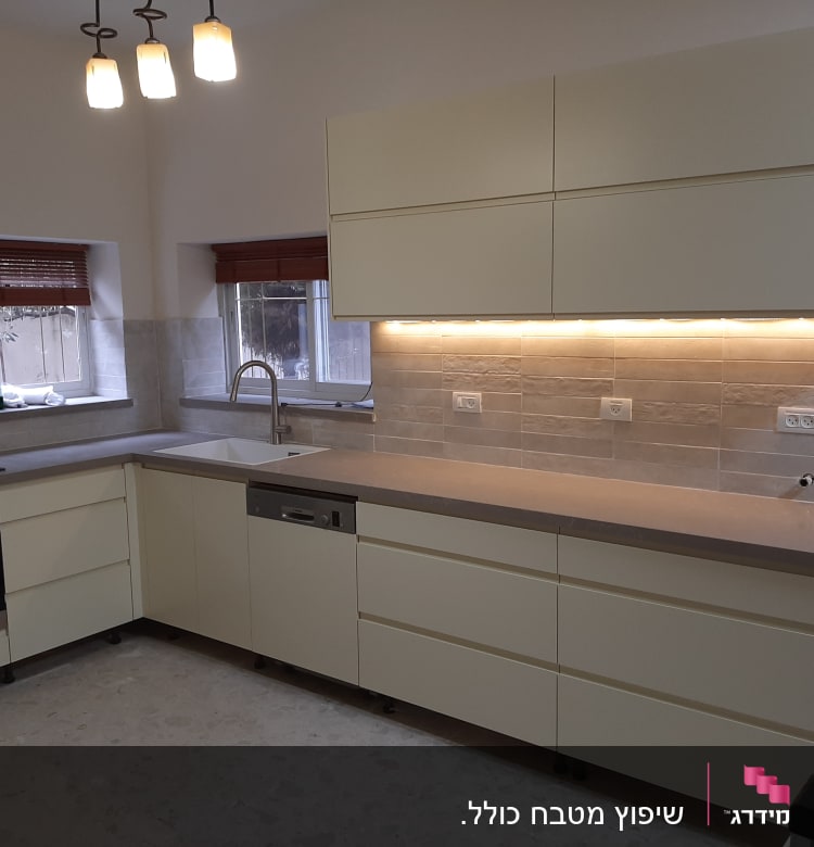 מטבח מודרני עם ארונות בהירים ותאורה תחתונה